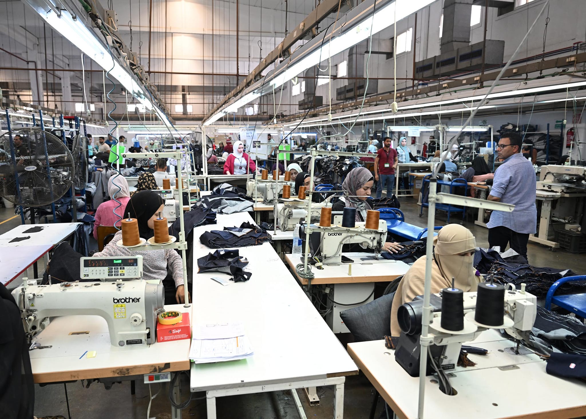 سير العمل في مصنع دينيم للملابس الجاهزة في بياض العرب
